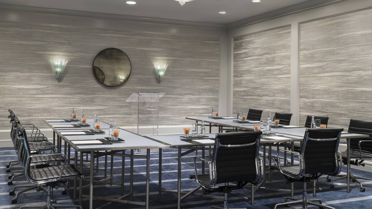 Presidio Suite meeting room with modular tables around glass podium