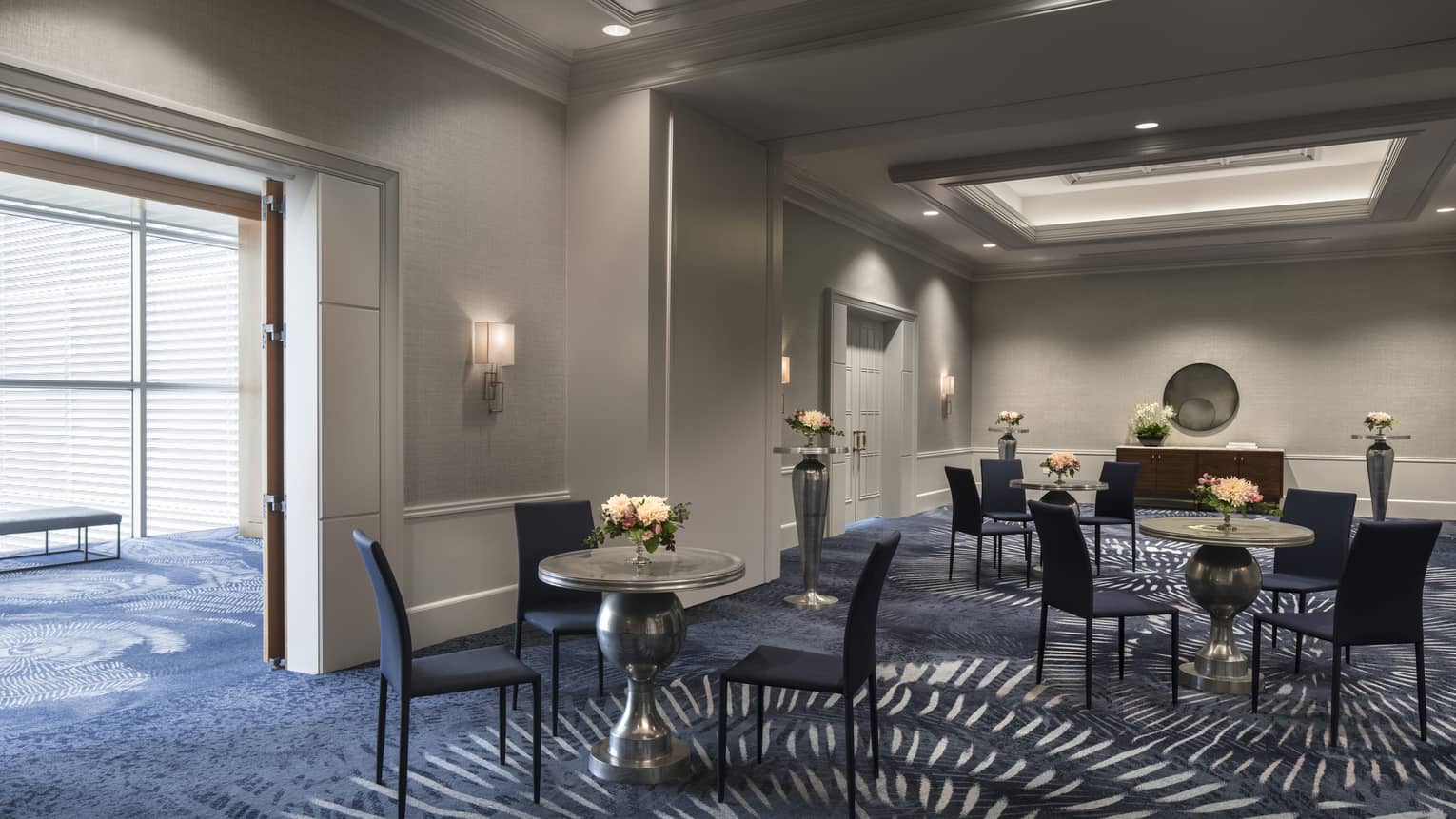 Three cafe tables and chairs in carpeted Yerba Buena pre-function room