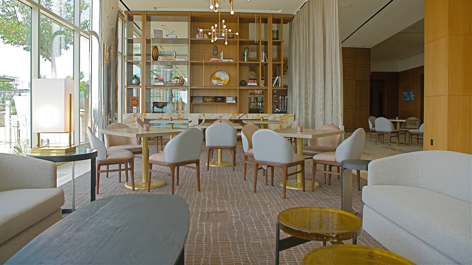A seating area with many grey chairs and small tables.