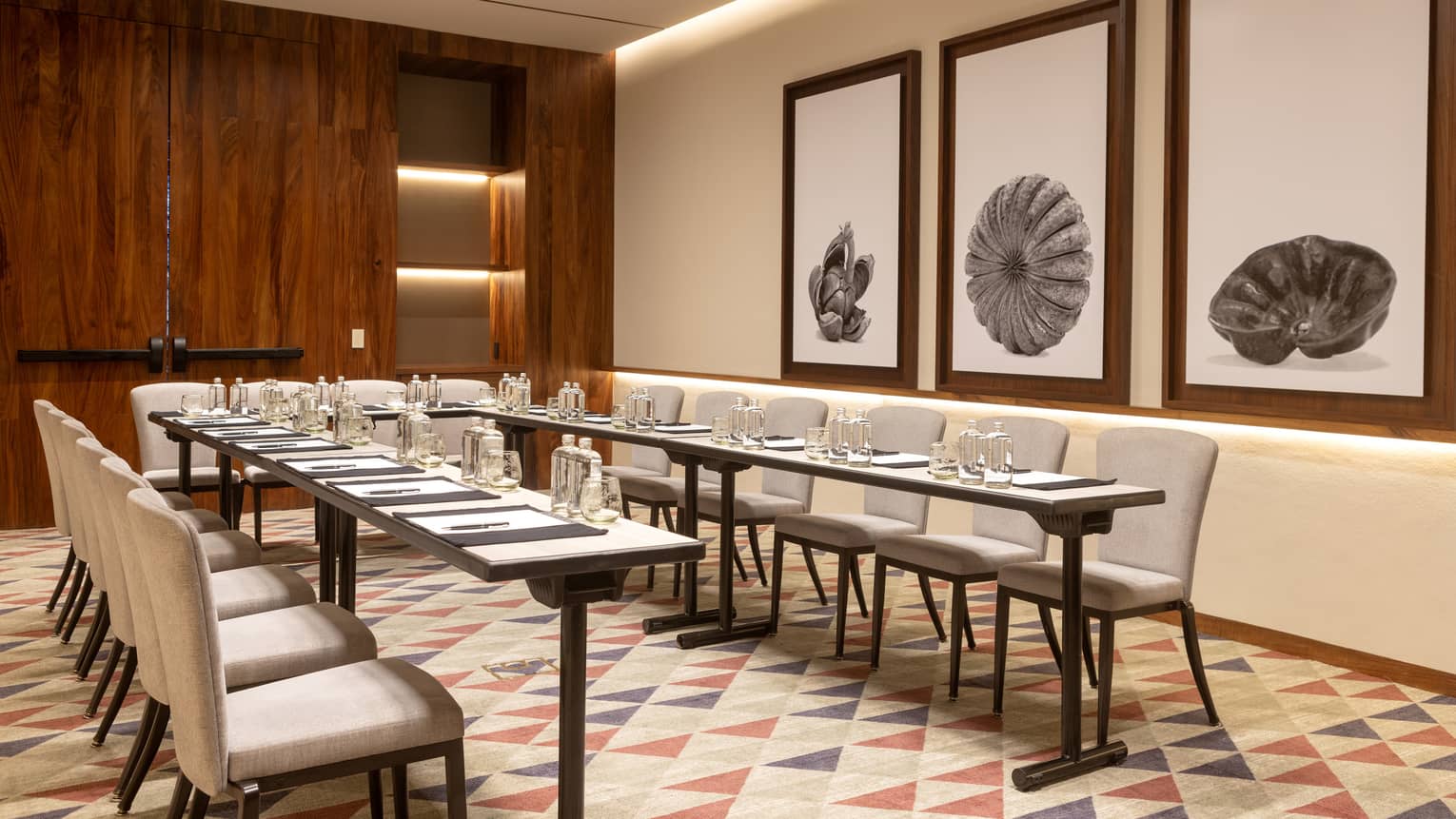 Event room with a U-shaped table and place settings.