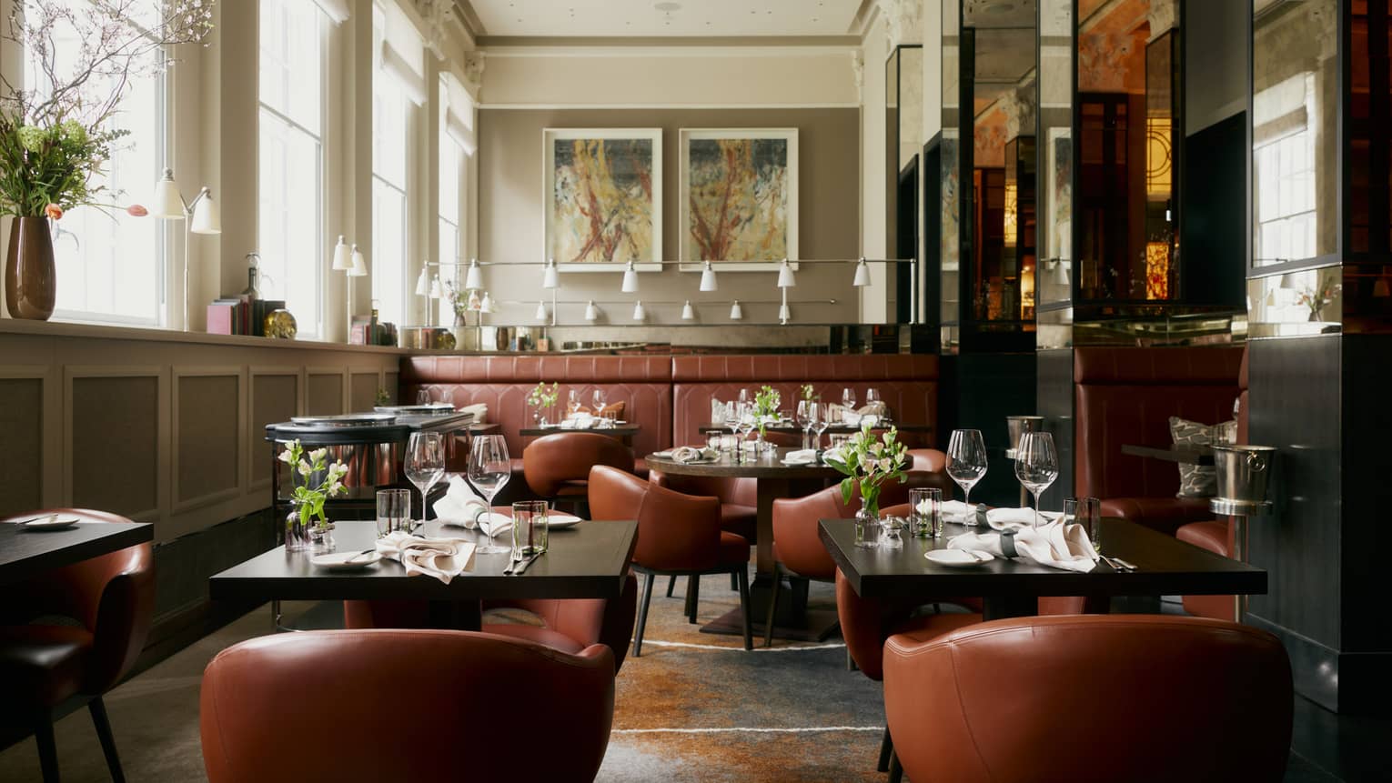 Restaurant featuring square black tables with tan leather chairs