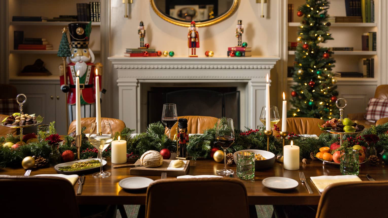 Table set infront of a fireplace and bookshelves is decorated for a holiday dinner