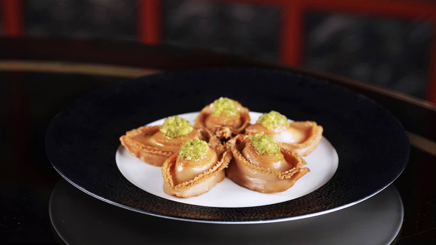 Marinated Fresh Abalone with Bell Pepper on a white and black plate