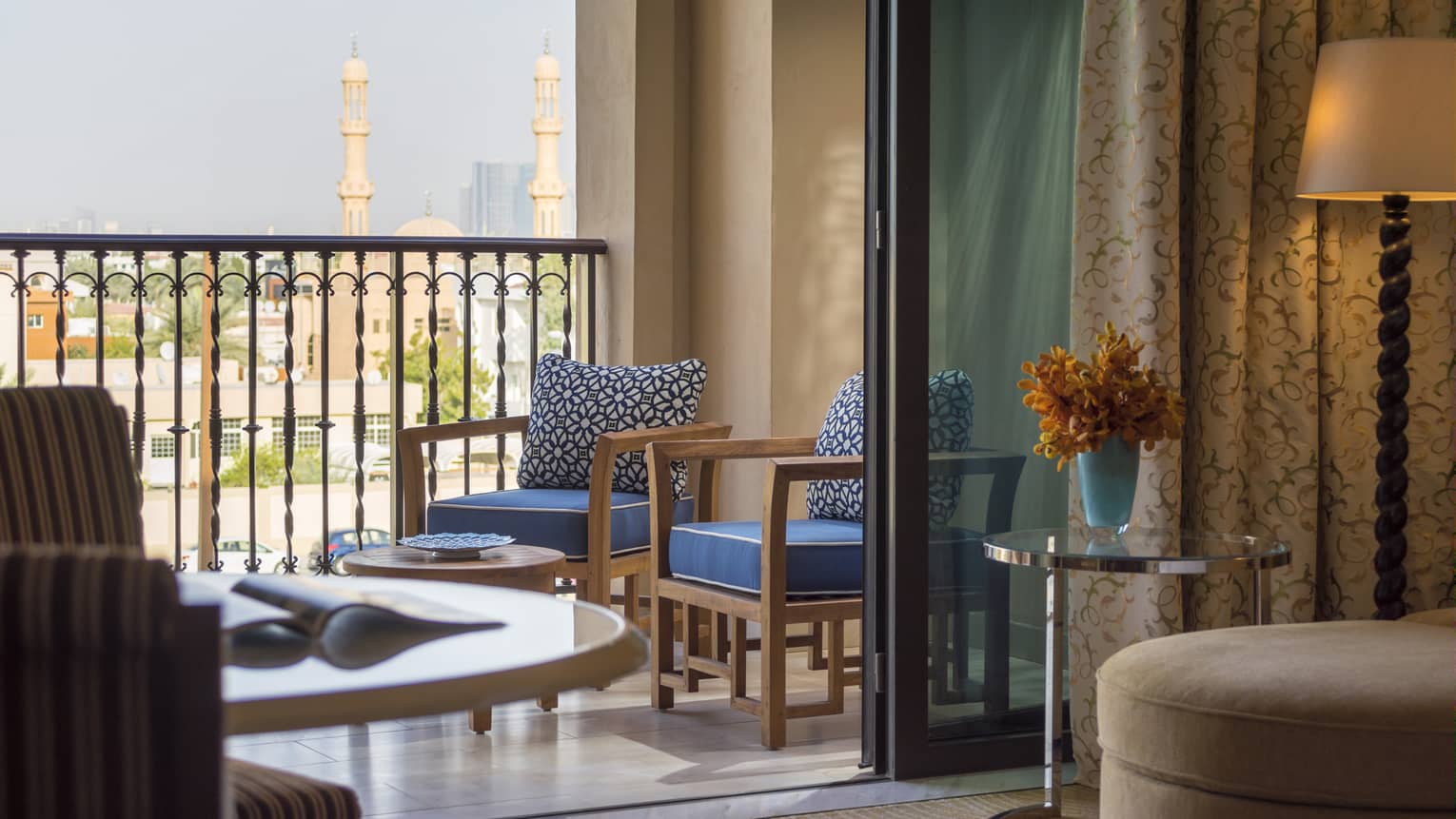 Hotel room terrace with two wooden chairs, view of Dubai