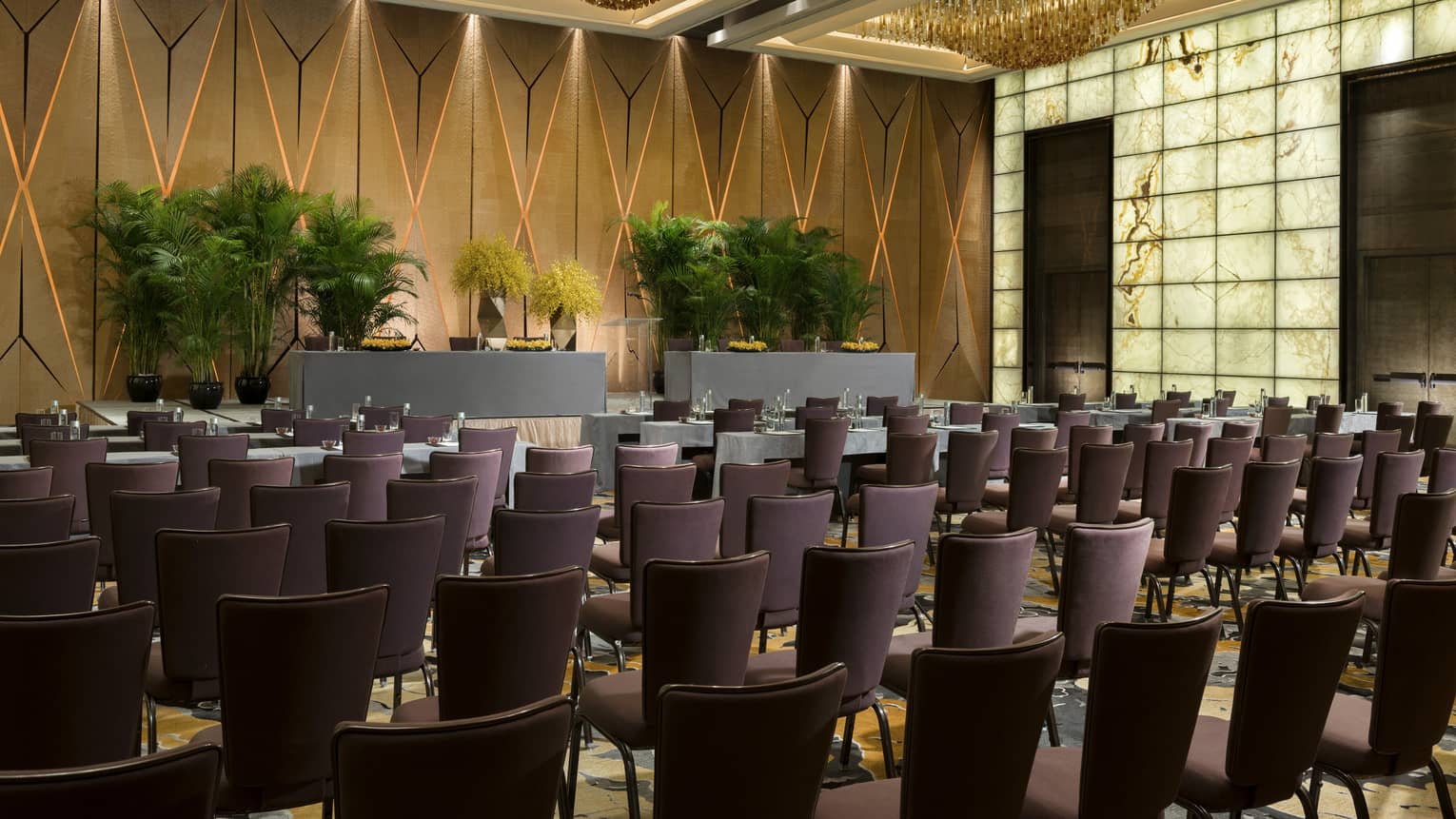 Pearl Ballroom conference with rows of meeting tables facing podium with potted trees 