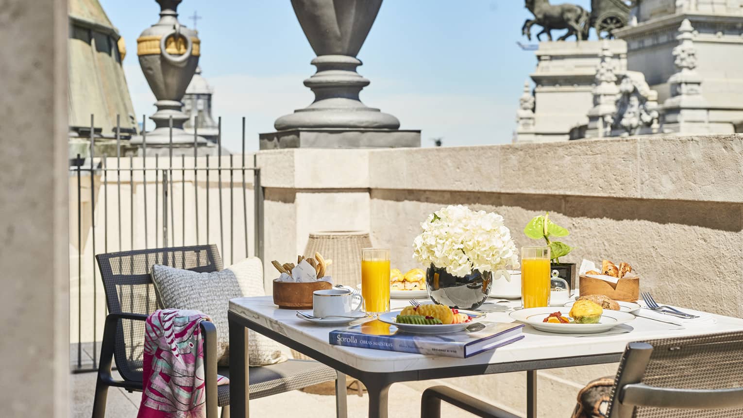 Dining table with two chairs on private terrace, with view of Madrid statue