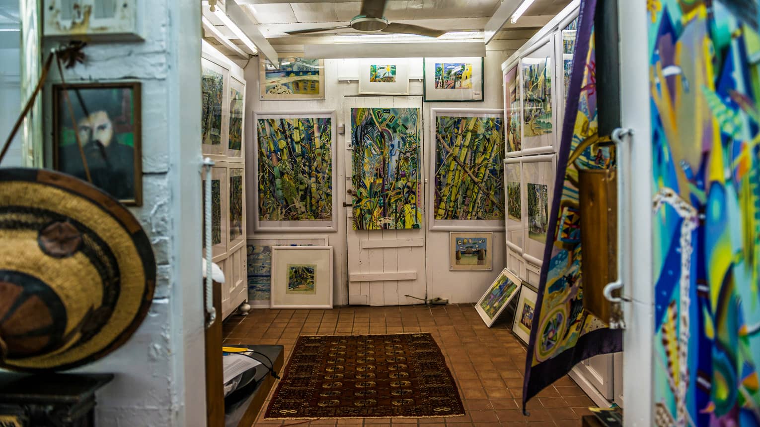 Interior of Michael Adams Gallery with colourful paintings on white walls 