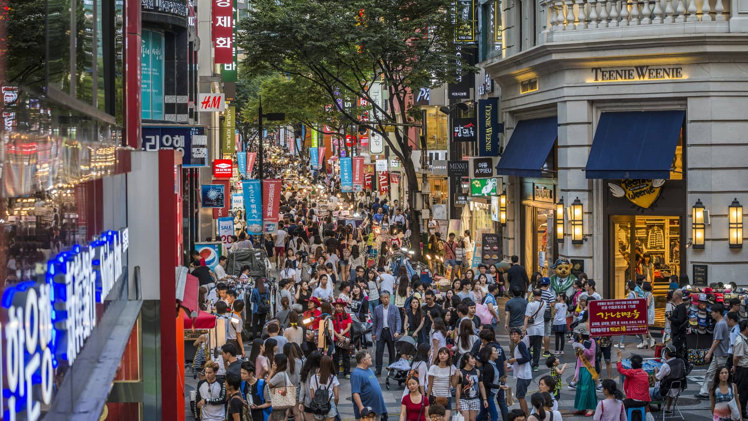 Crowded shopping area in Gwanghwamun district with people wandering along street