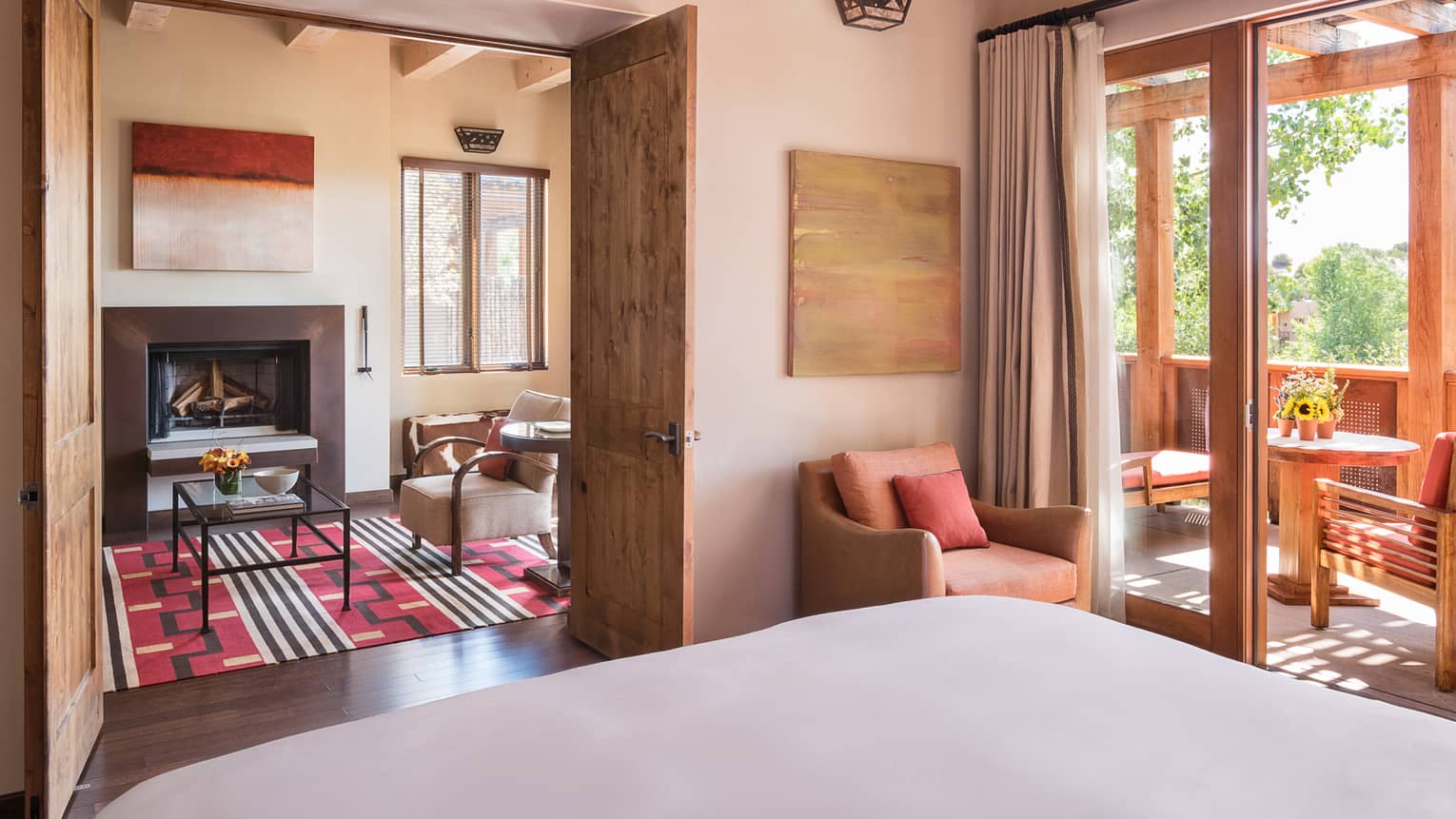 Sunset, Summit Suite bed, chair, open wood doors to seating area, sunny balcony