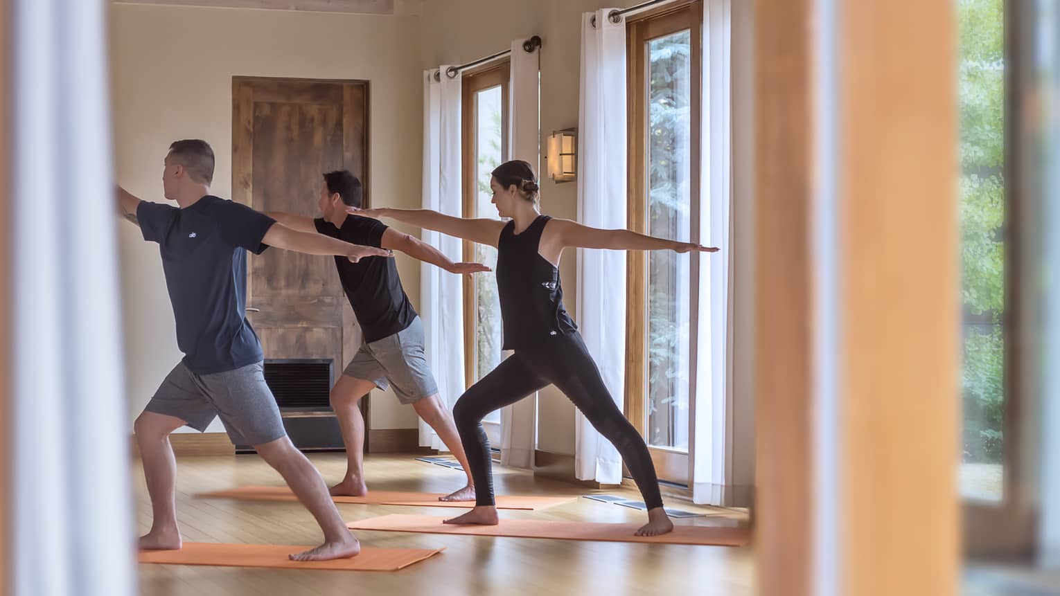 Three people perform yoga pose in Fitness Centre