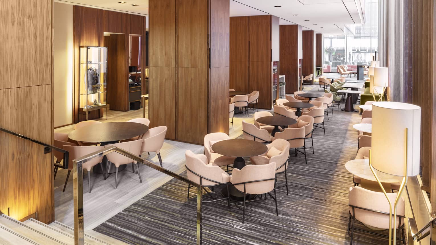A lounge with upholstered sofas, wood tables and wooden cabinets