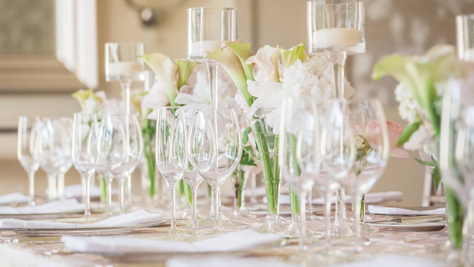 Wedding table setting with empty wine glasses, orchid flowers, glass candles