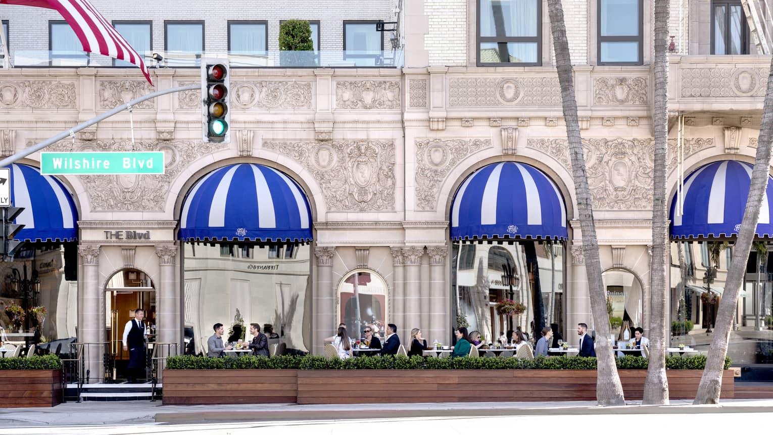 A patio where people are eating outside of a stone building.