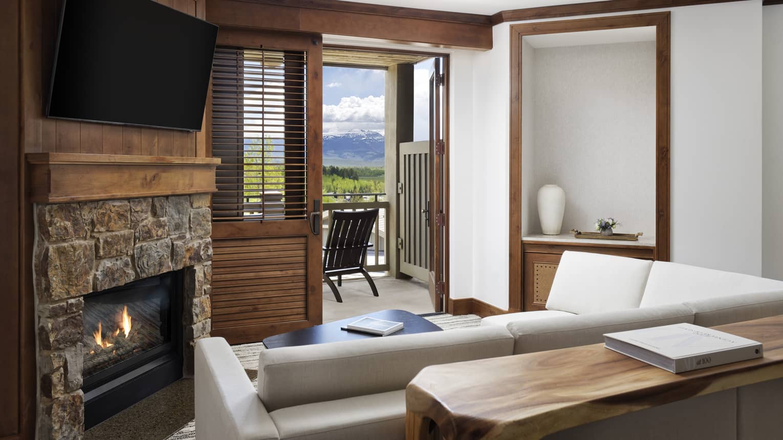 Living room with sofa, fireplace, wall-mounted TV and balcony