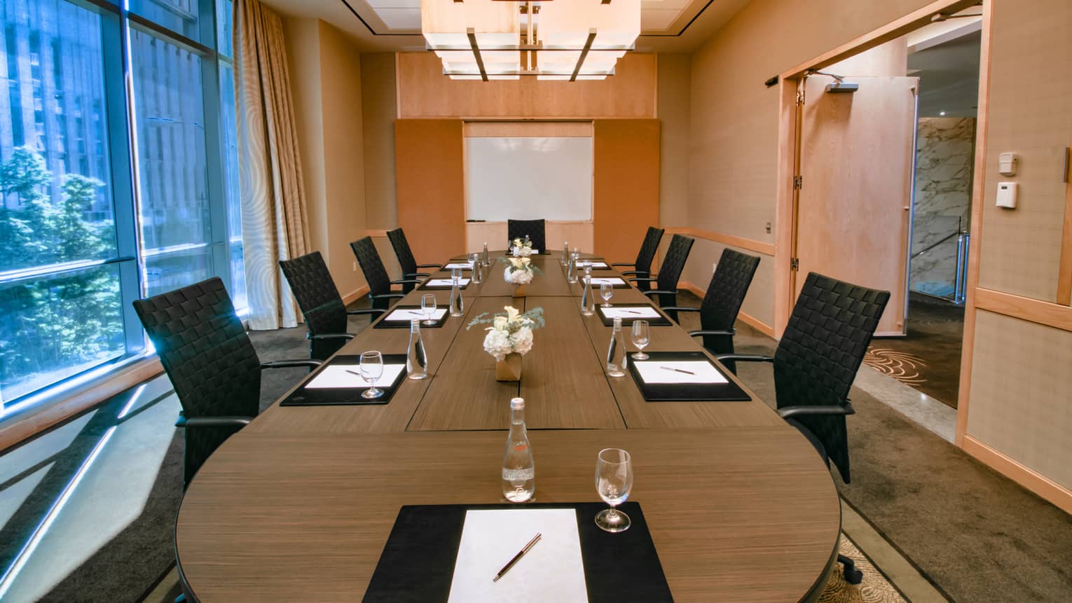 Maple Room wood boardroom meeting table lined with black chairs