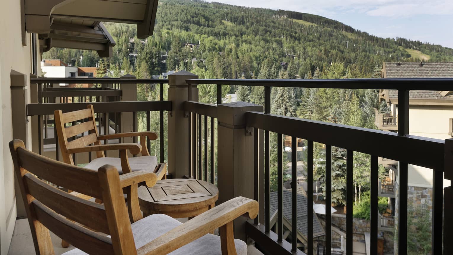 Balcony with portico, two wooden rocking chairs and small round table, mountain views