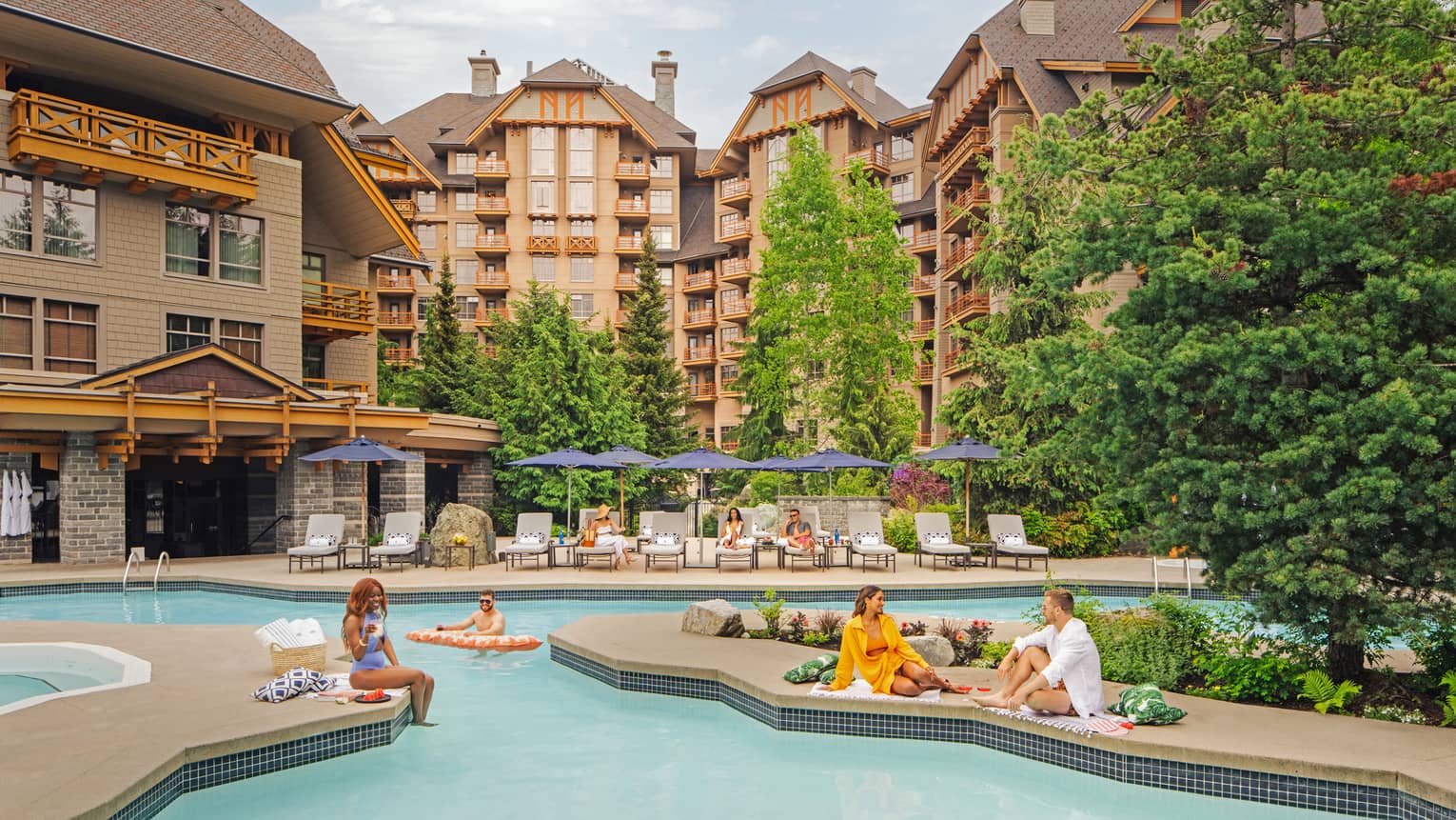 People lounging around an outdoor pool with large hotel buildings in the background.