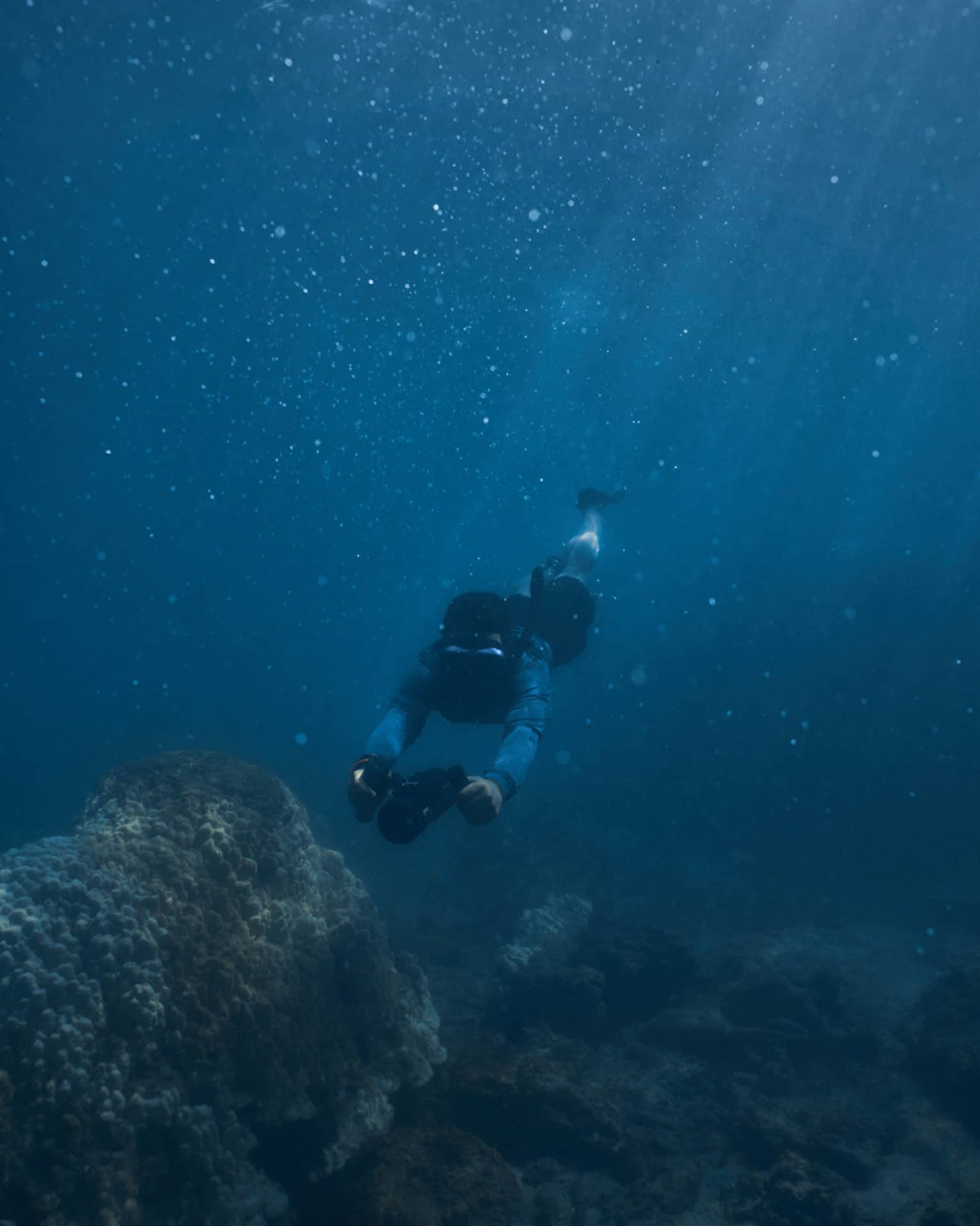 Person diving beneath the water using dive scooter