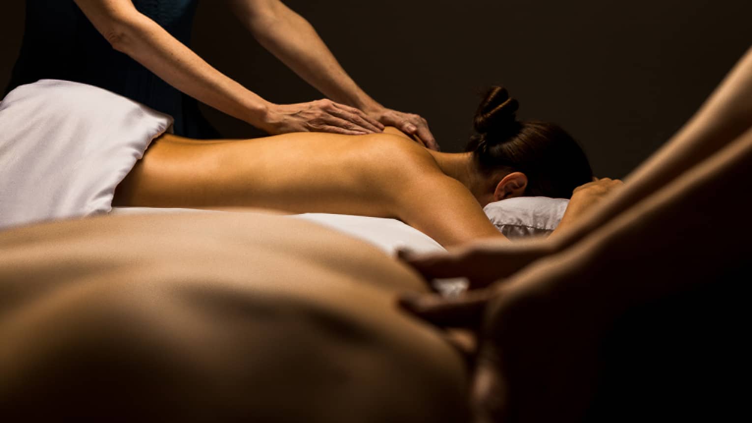 Two guests lay side by side for massage treatments