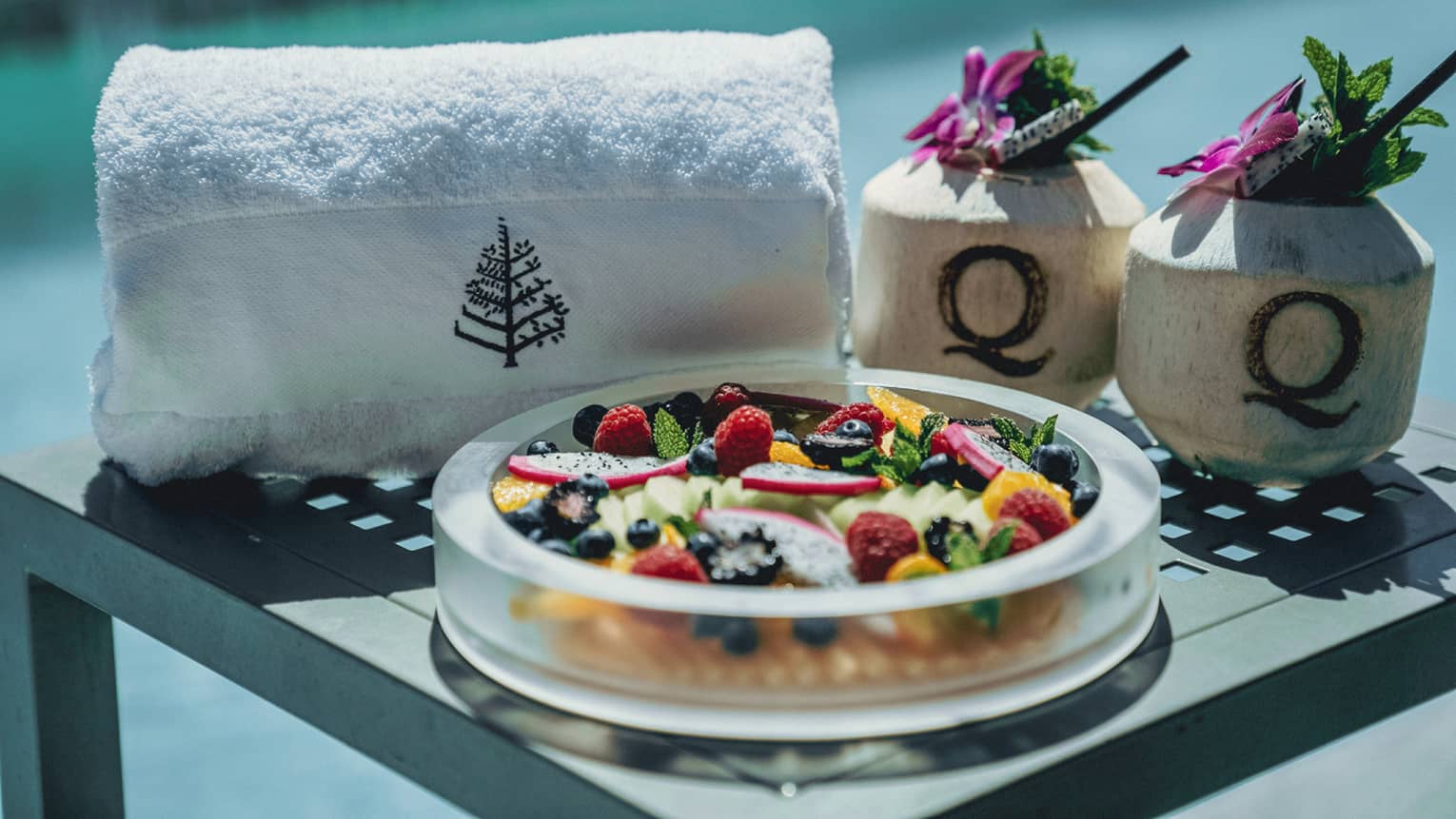 A bowl of fruit near a towel.