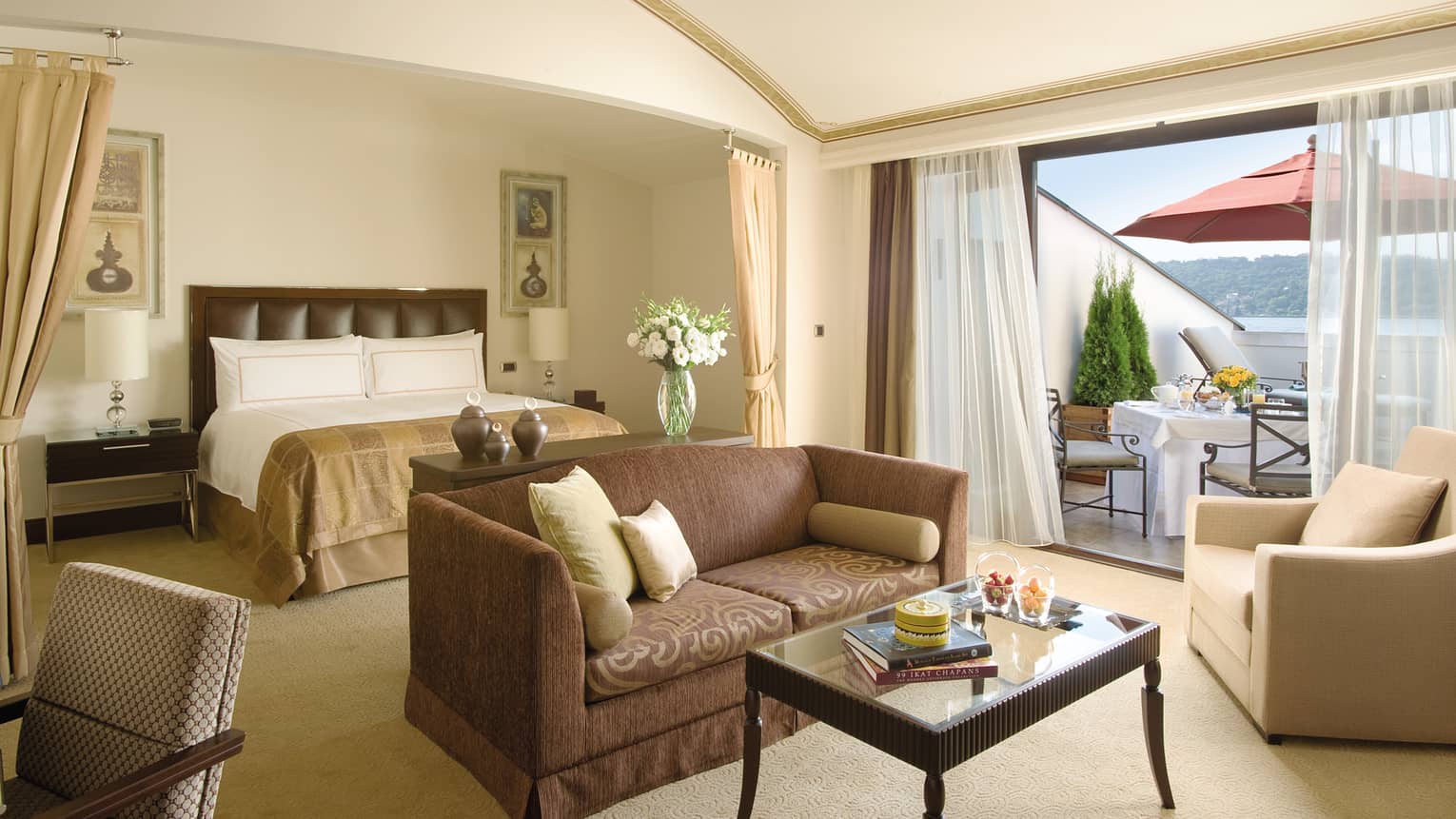 Palace Roof Suite open-concept room with bed behind loveseat sofa, sunny window