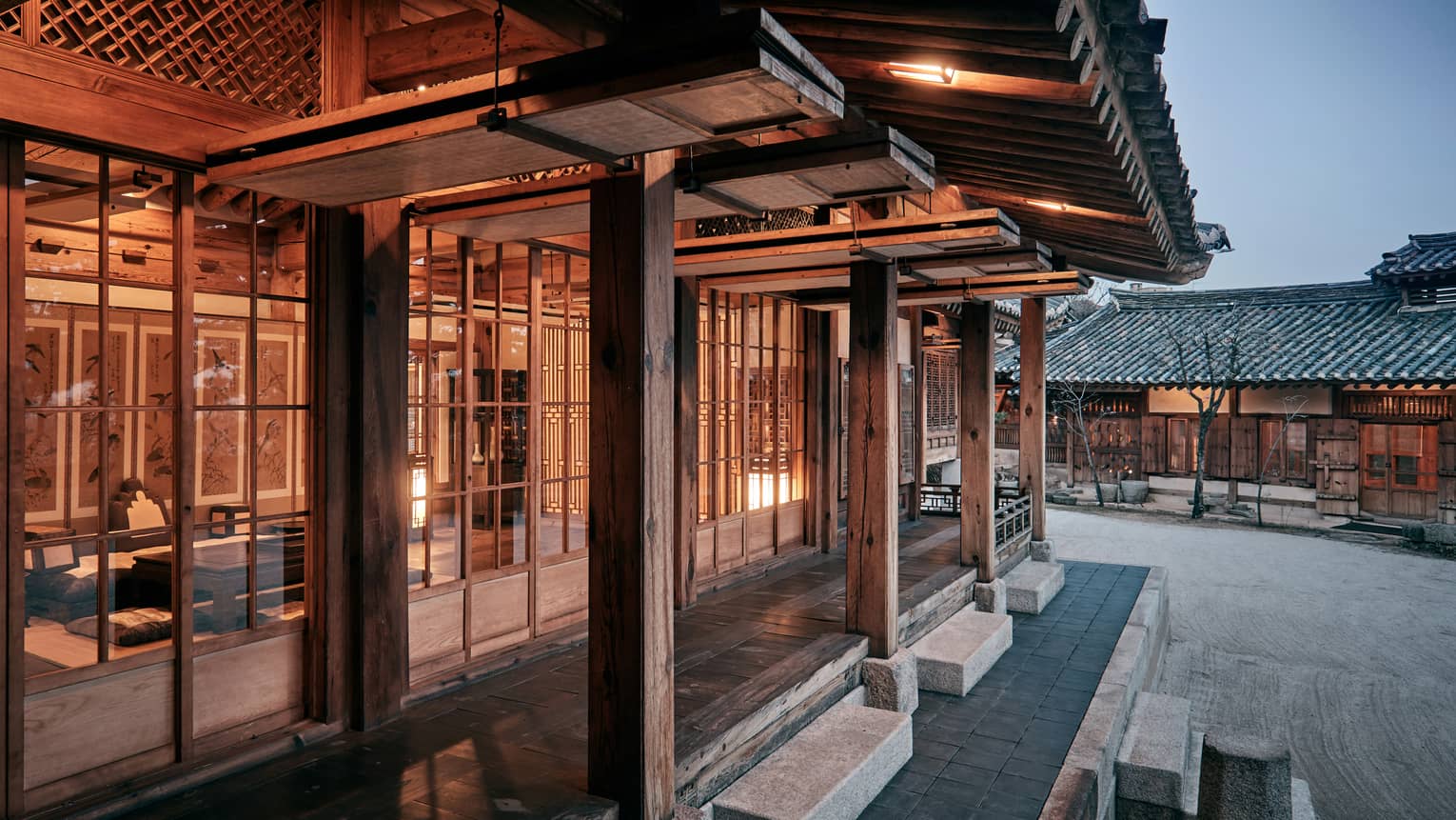 Korea Furniture Museum exterior, cement steps, rustic wood pillars outside windows with wood frames, lights