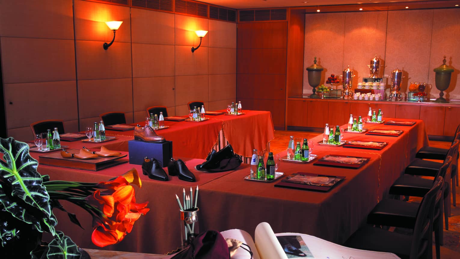 Accademia Room with U-shaped meeting table with red linens, Italian shoes and book