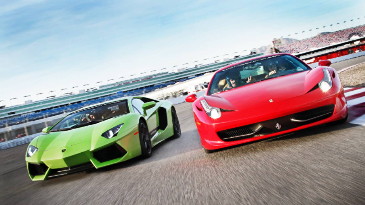 Red and green sports cars on race track