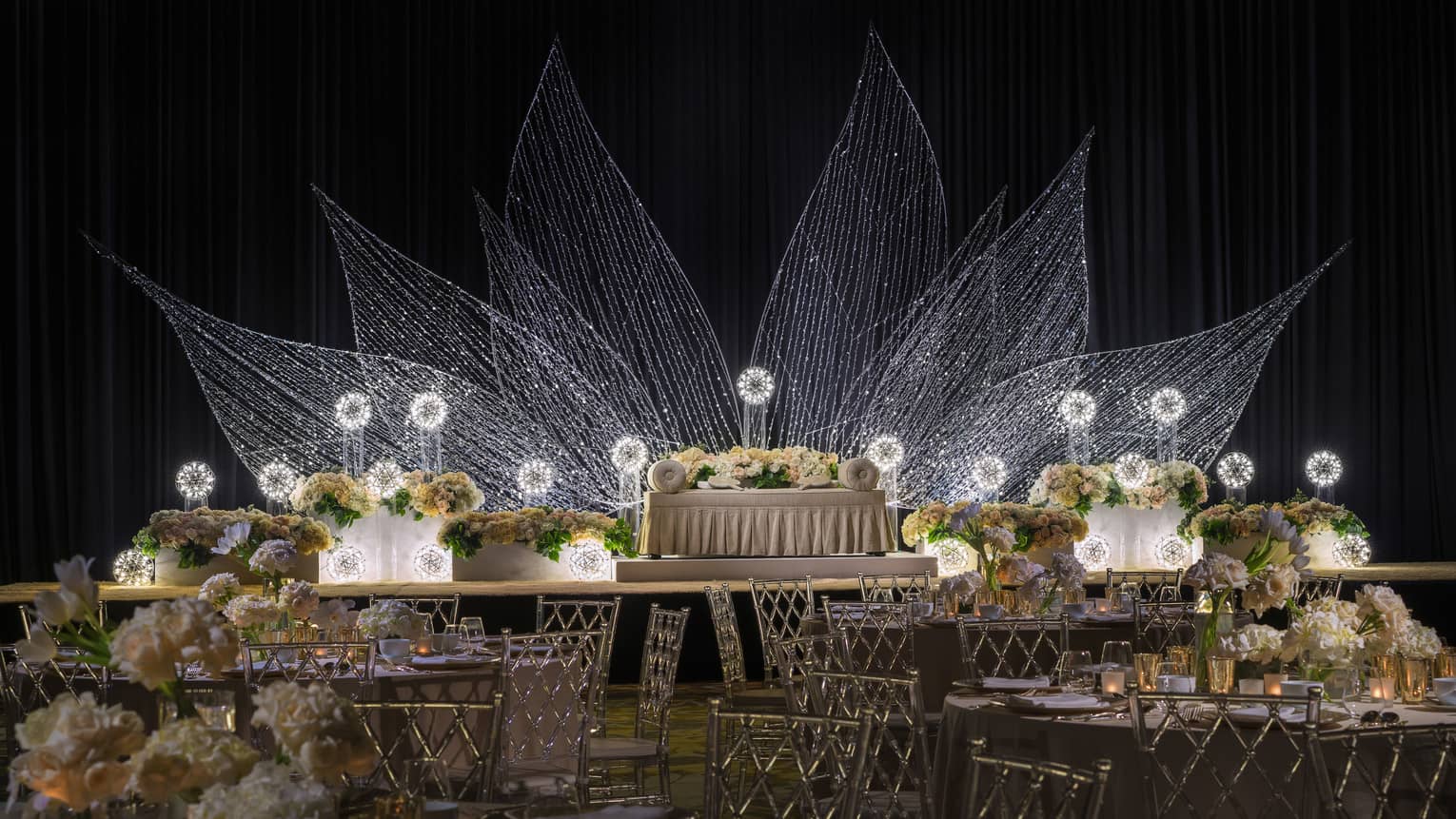 Malay wedding with banquet tables, white loveseat in front of flower light display