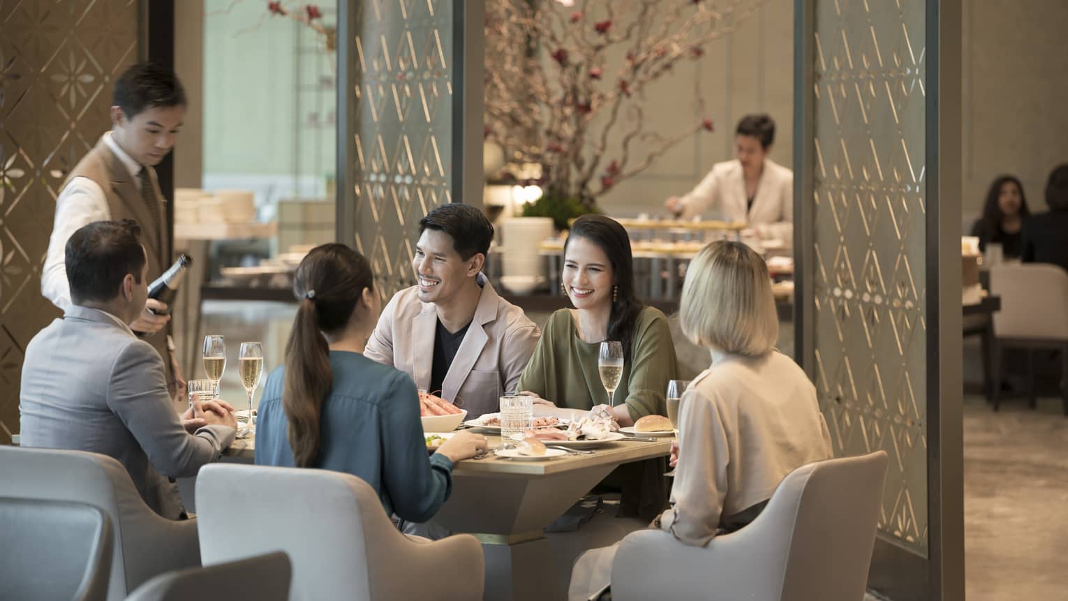 Group of laughing friends enjoy brunch at Curate