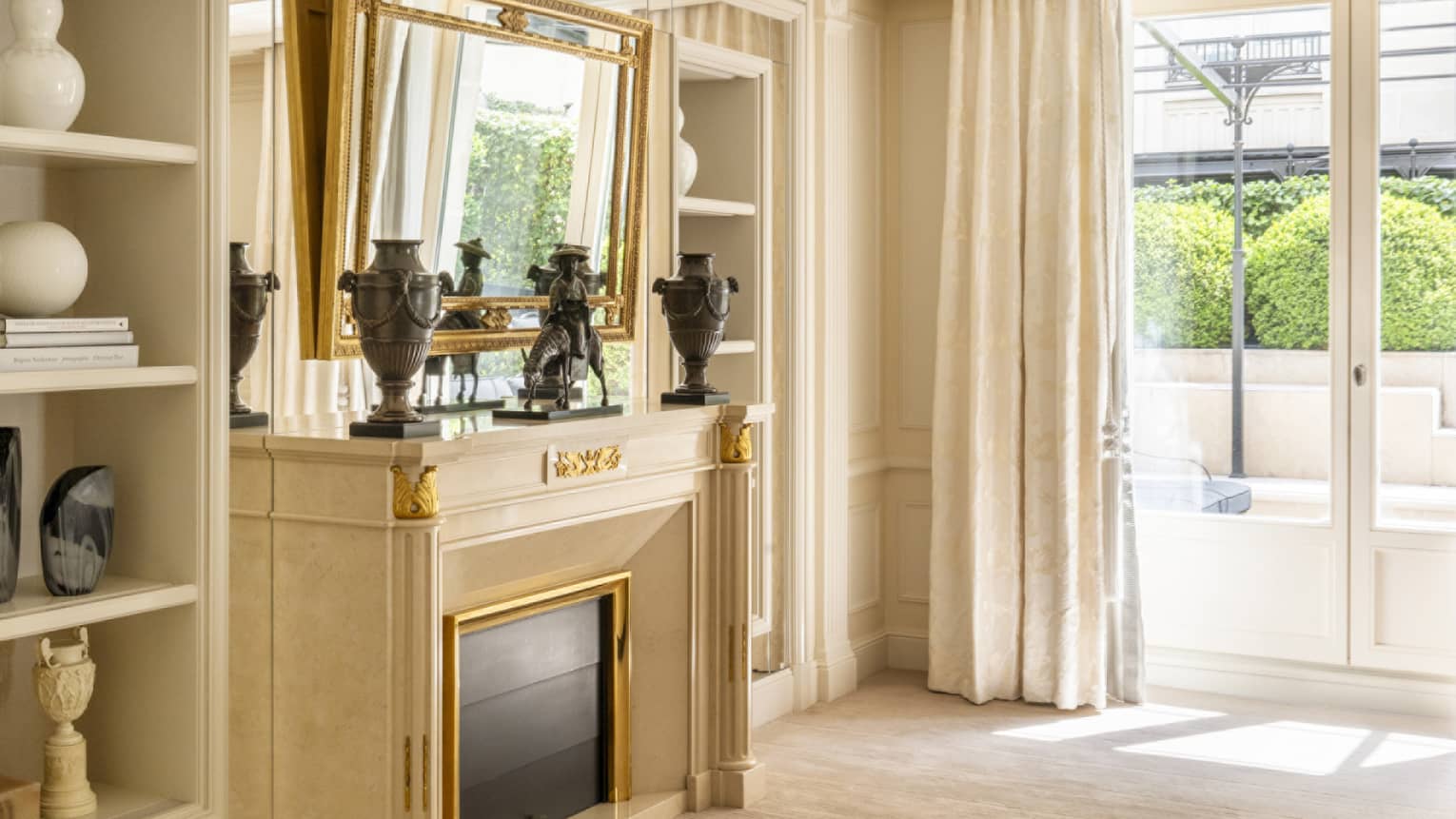 A mirror hangs over a fireplace in a luxury hotel suite