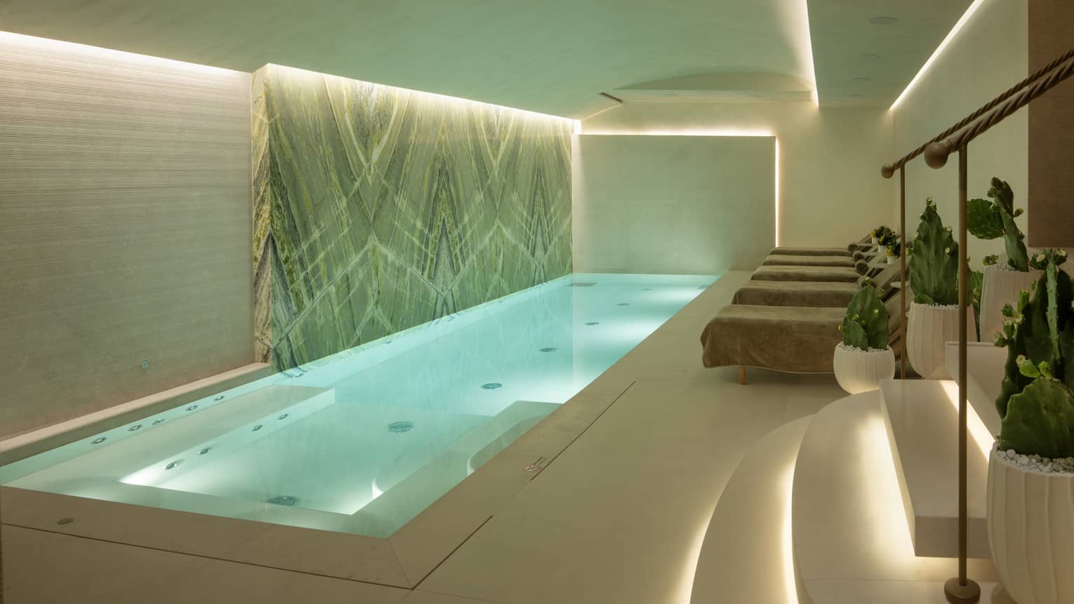 Indoor spa pool with uplit ceiling and steps