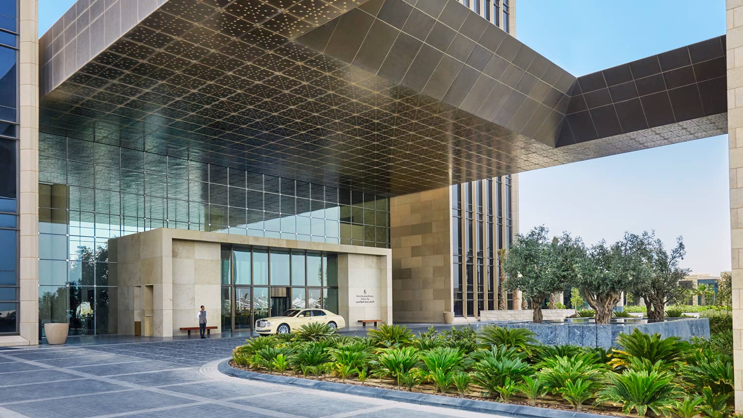 Four Seasons Hotel Bahrain Bay front entrance, car in front of door, door person, tropic garden