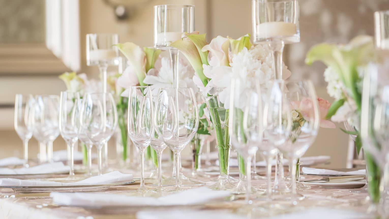 Wedding table setting with empty wine glasses, orchid flowers, glass candles