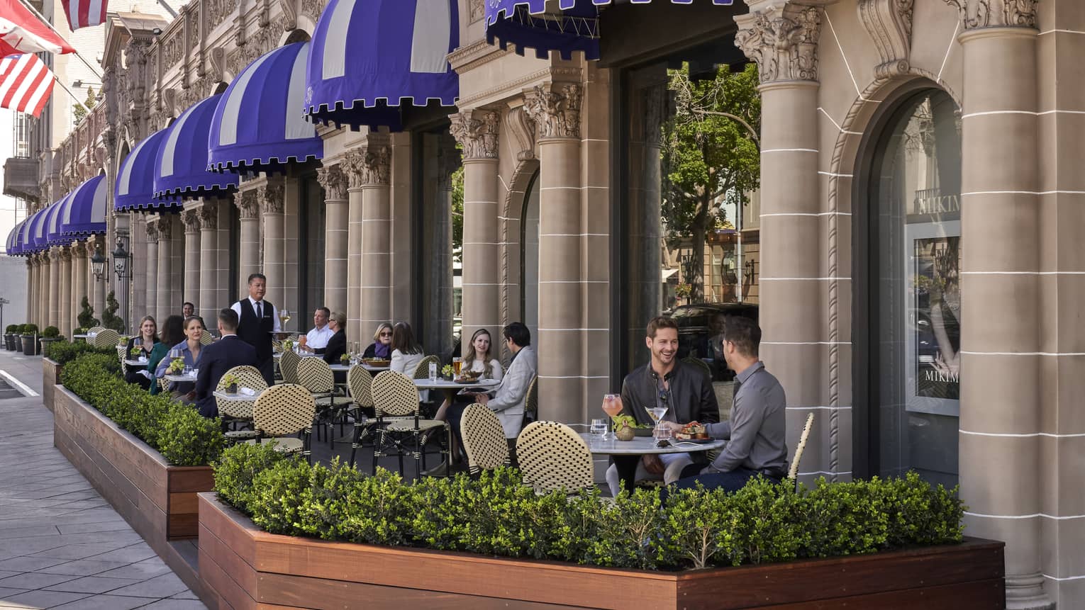 A patio eating area outside of a stone building.