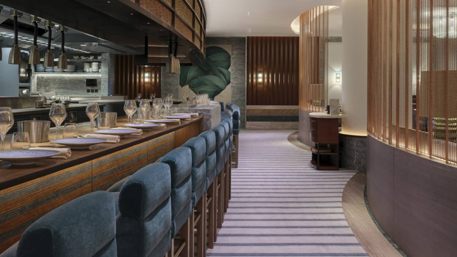 The bar of a restaurant with blue stools and wood furnishings.