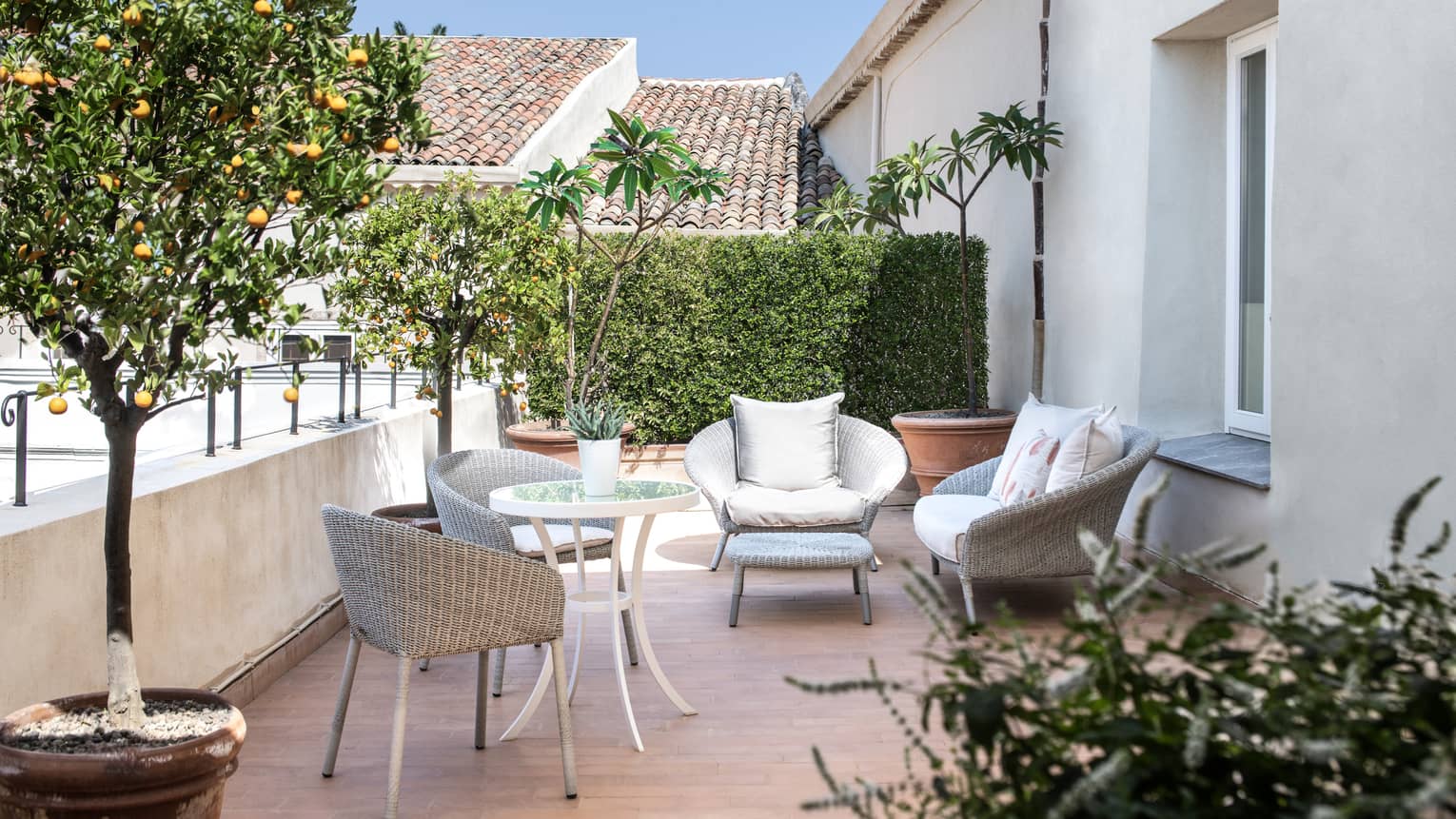 A terrace with chairs, small tables and plants.