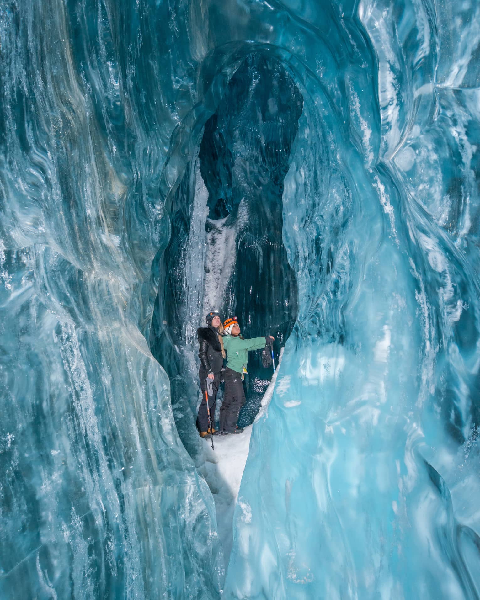 Two people walking in an ice cave in Whistler