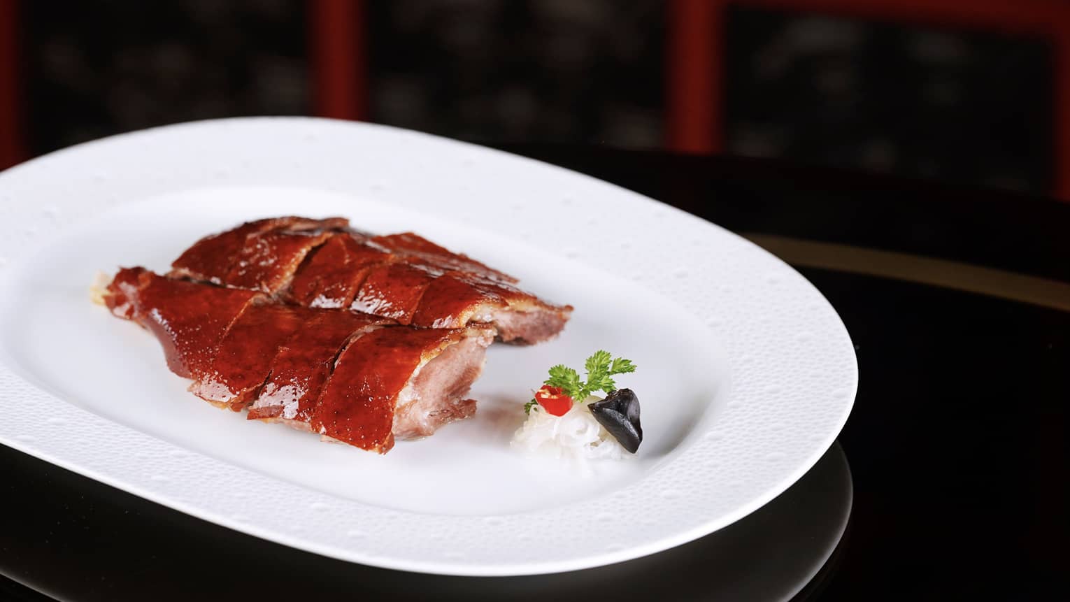 Cantonese roasted goose with crispy skin on a white plate