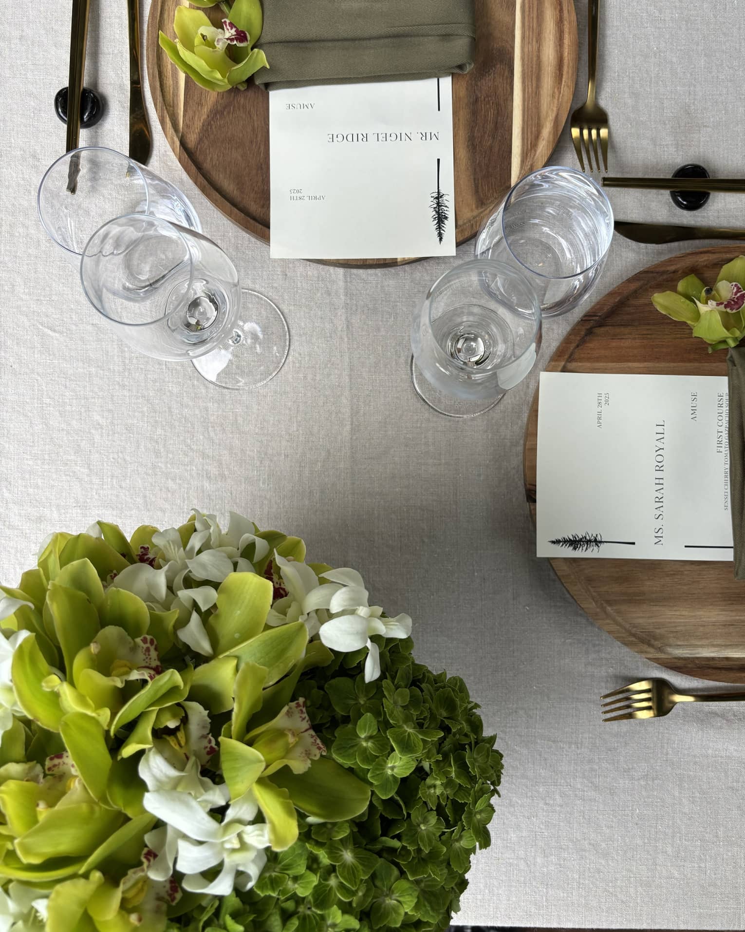Table setting for two with green floral arrangement