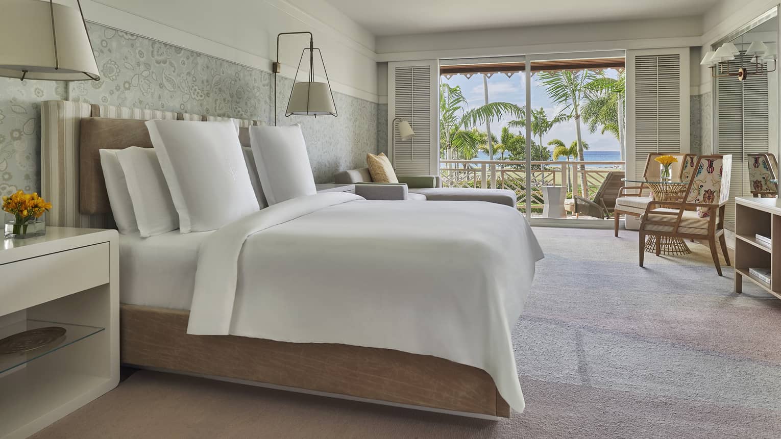 Luxury Suite with modern white decor, hotel bed under ceiling fan, sunny patio door