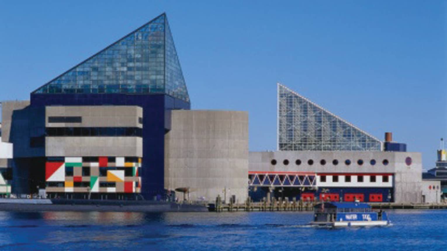 Angular glass roofs, painted murals of Baltimore National Aquarium building exterior
