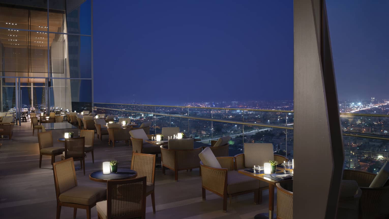 Several tables set up on the outdoor terrace overlooking Kuwait