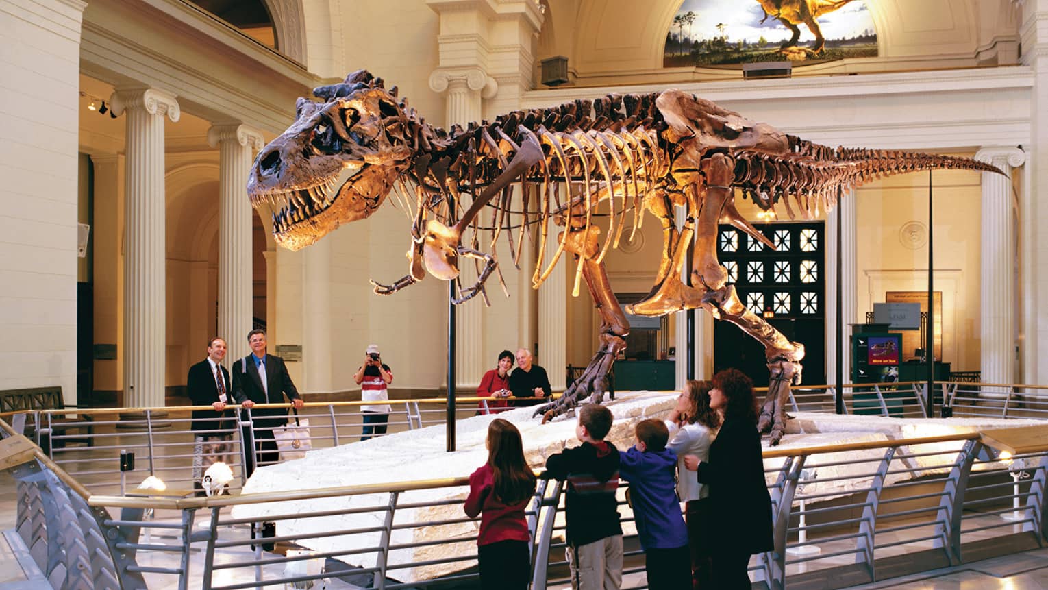Family looks up at dinosaur bones in museum