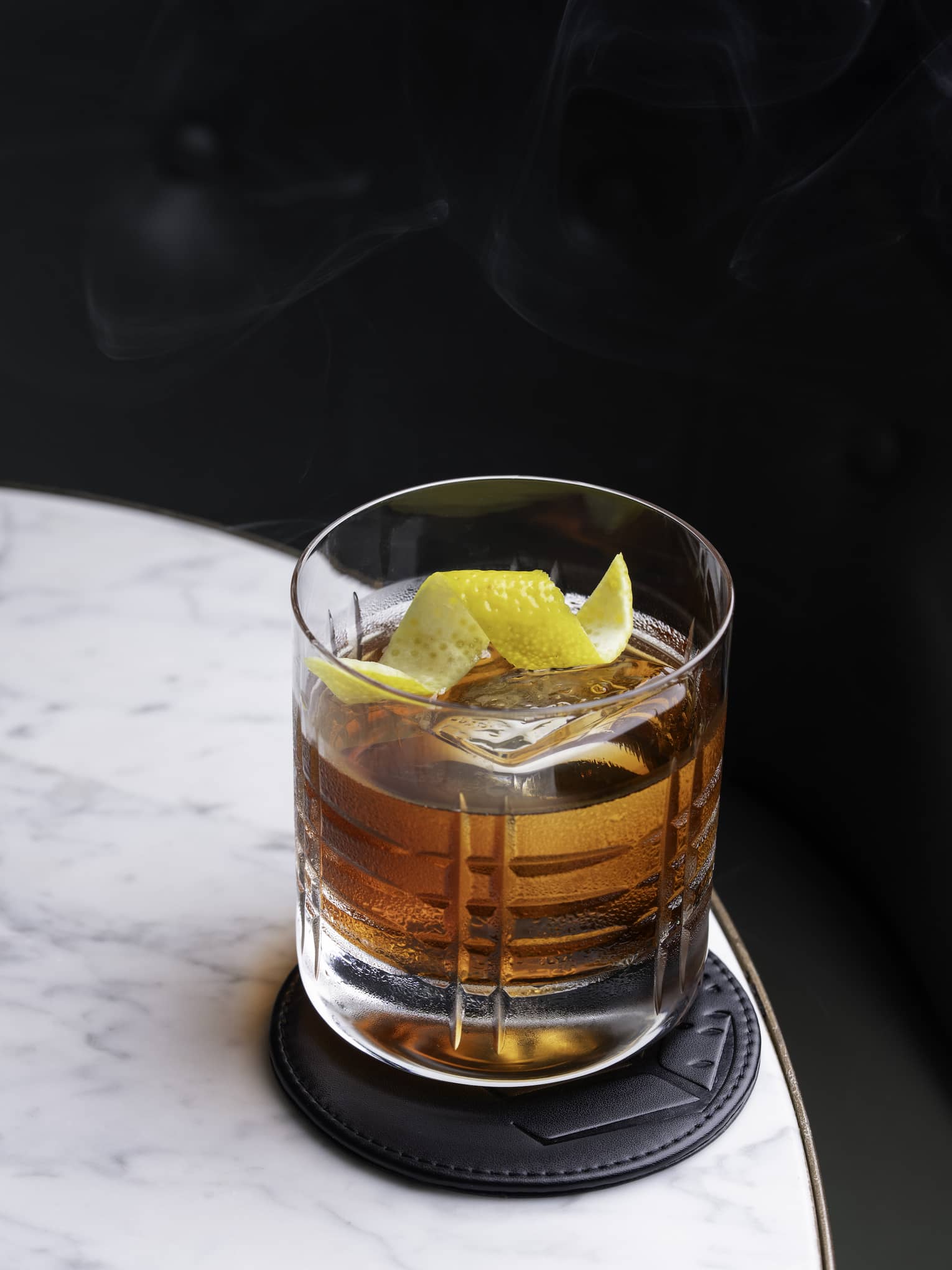 Old Fashioned cocktail on a marble table