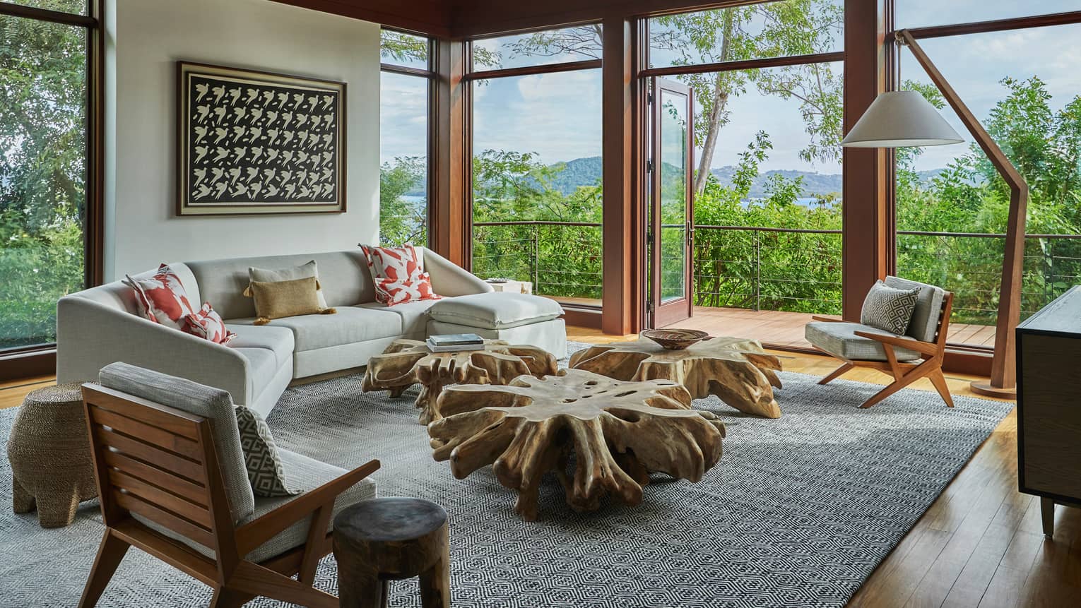 Miramar Suite curved sofa, modern armchairs around rustic reclaimed wood tables, corner picture windows