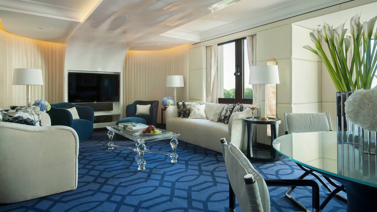 Blue Suite living room white sofas, table, TV over modern blue carpet