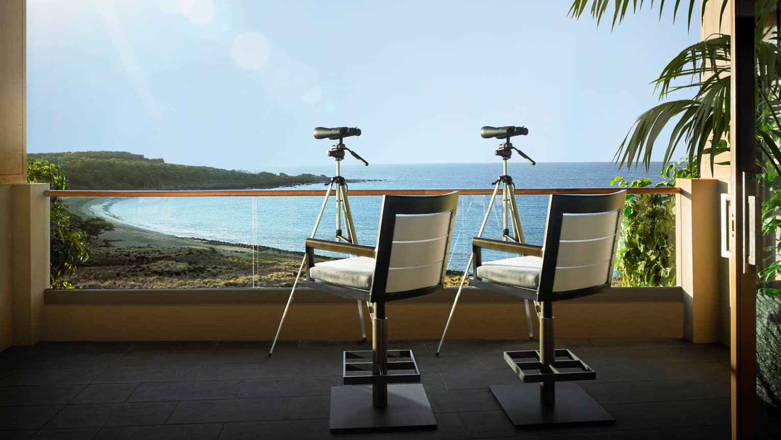 Two chairs and telescopes on a private balcony, overlooking Hawaiian beach