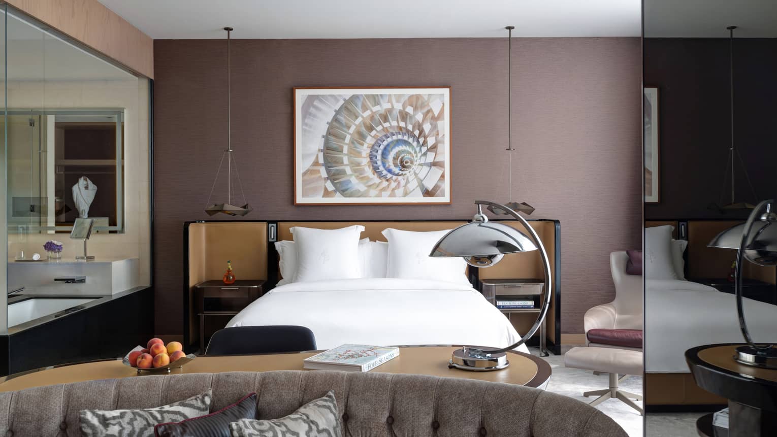 Bedroom with brown wall, artwork, king bed and sitting area