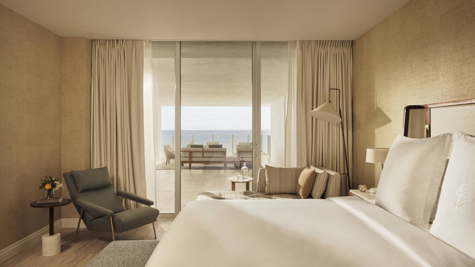 Bedroom with king bed, arm chair, walk-out ocean-view balcony